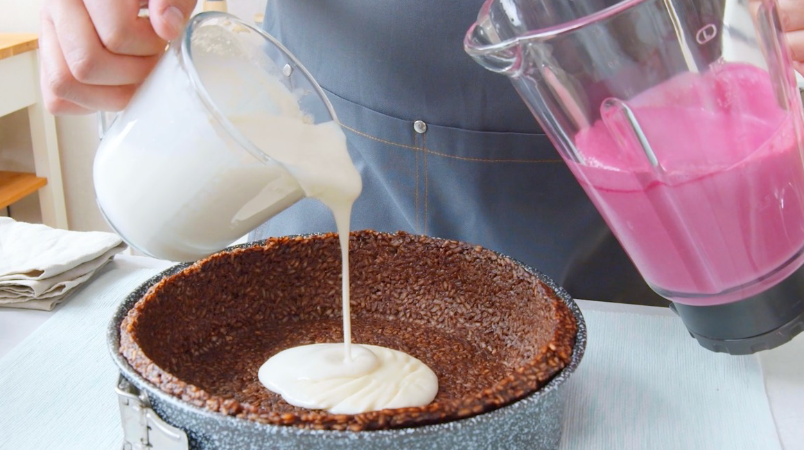 Zebrakuchen aus Milchreis: die Cremes in Weiß und Rosa werden auf den Kuchenteig gegossen.