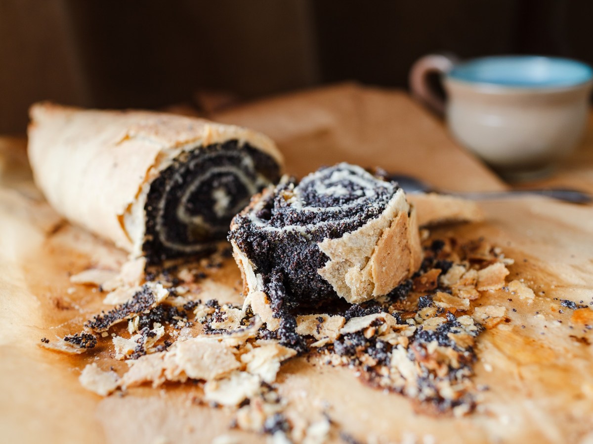 Ein angeschnittener Mohnstrudel auf Backpapier