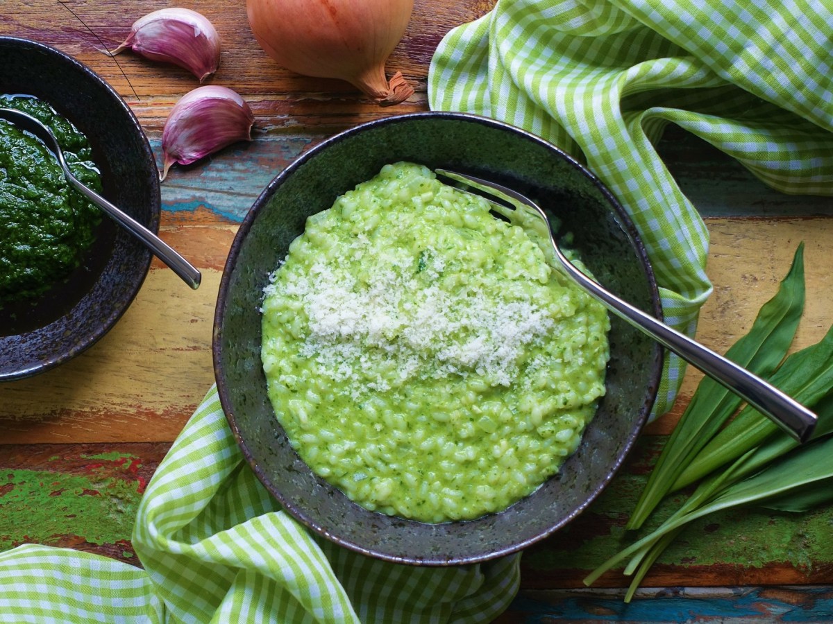 Ein Teller mit Bärlauch-Risotto mit Bärlauch, Knoblauch daneben