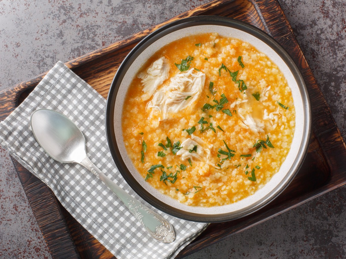 Italienische Pastina-Suppe mit Hühnchen auf einem Tablett.