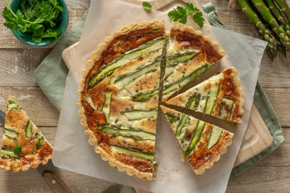 Eine Spargel-Quiche in der Draufsicht, aus der mehrere Stücke geschnitten wurden.