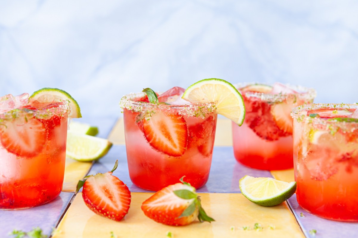 Alkoholfreie Erdbeerbowle in vier Gläsern, garniert mit Erdbeeren und Limetten.