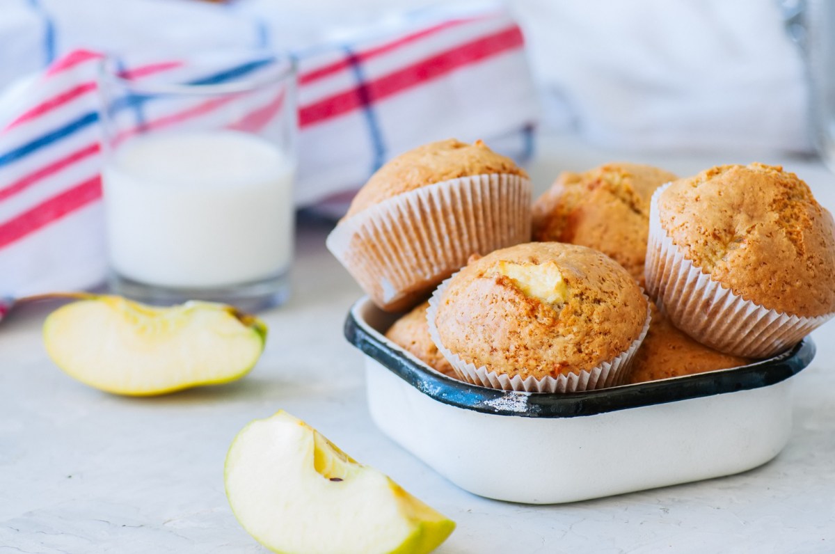 Kleine Schale mit Apfel-Muffins ohne Zucker und Apfelstücken daneben