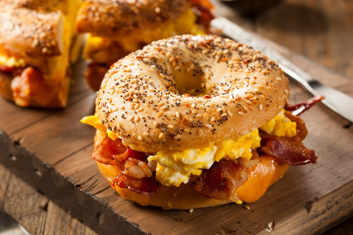 Bagel mit Rührei und Bacon auf einem Brett