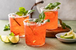 Drei Gläser mit Erdbeer-Basilikum-Margarita und Limettenspalten