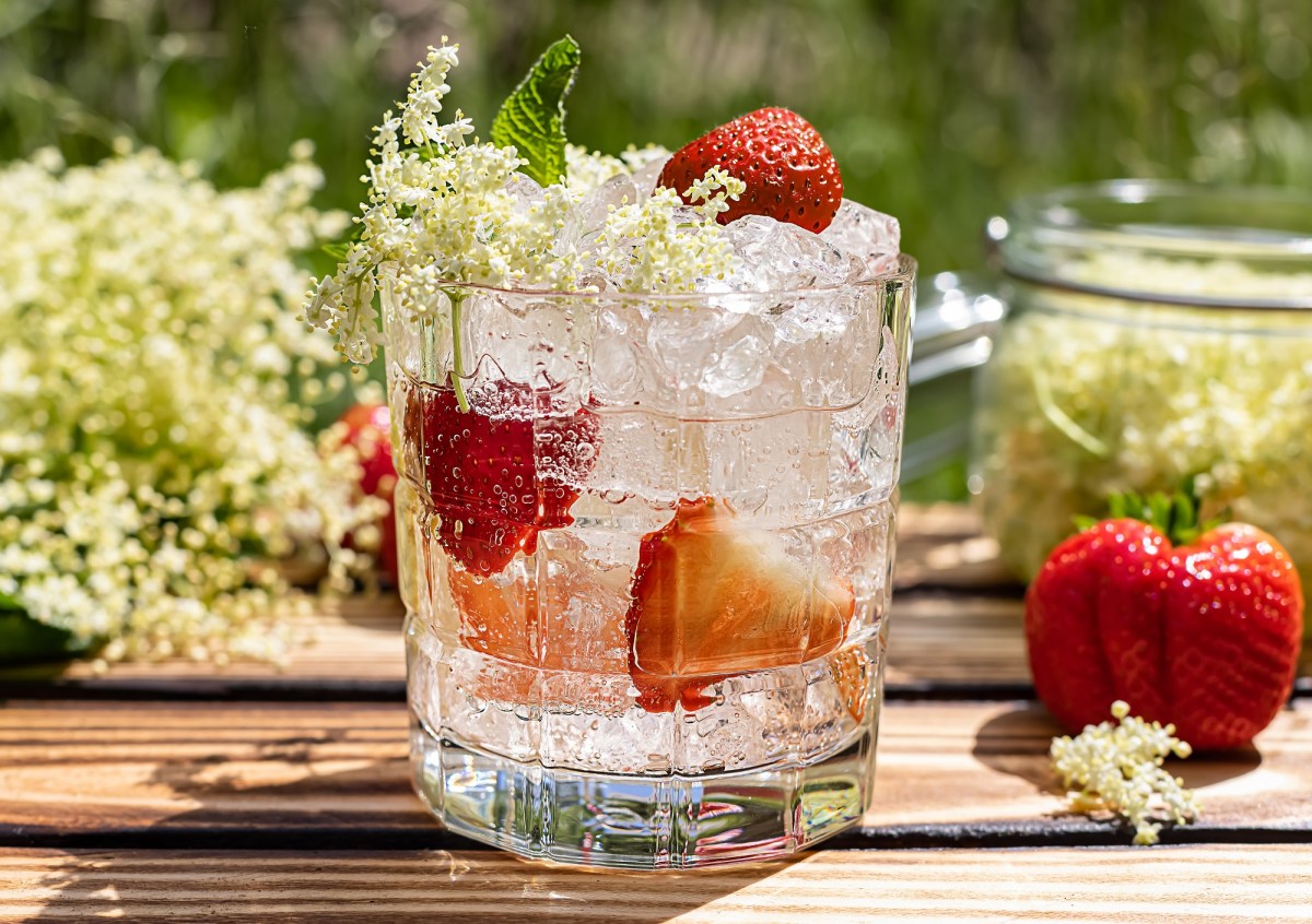 Glas mit Erdbeer-Hugo und Holunderblüten