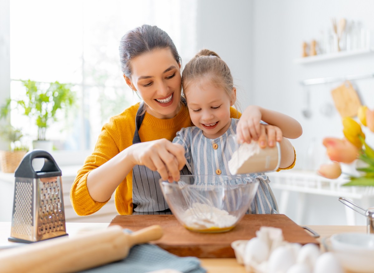 Kochen und Backen mit Kindern: Eine Mutter backt mit ihrer Tochter einen Kuchen.