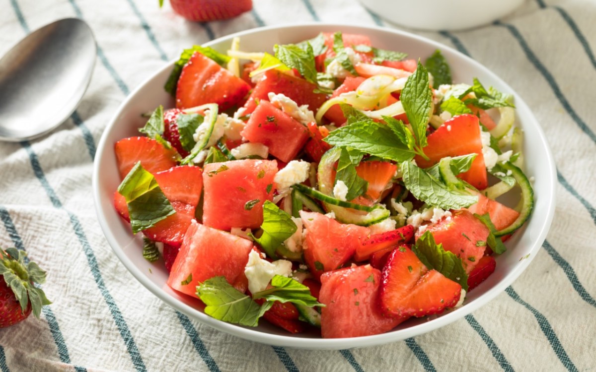 Ein Erdbeer-Melonen-Salat mit Feta in einer flachen Schale.