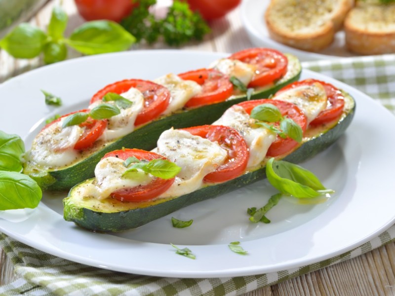 Zwei gegrillte Zucchini mit Tomate-Mozzarella und Basilikum.