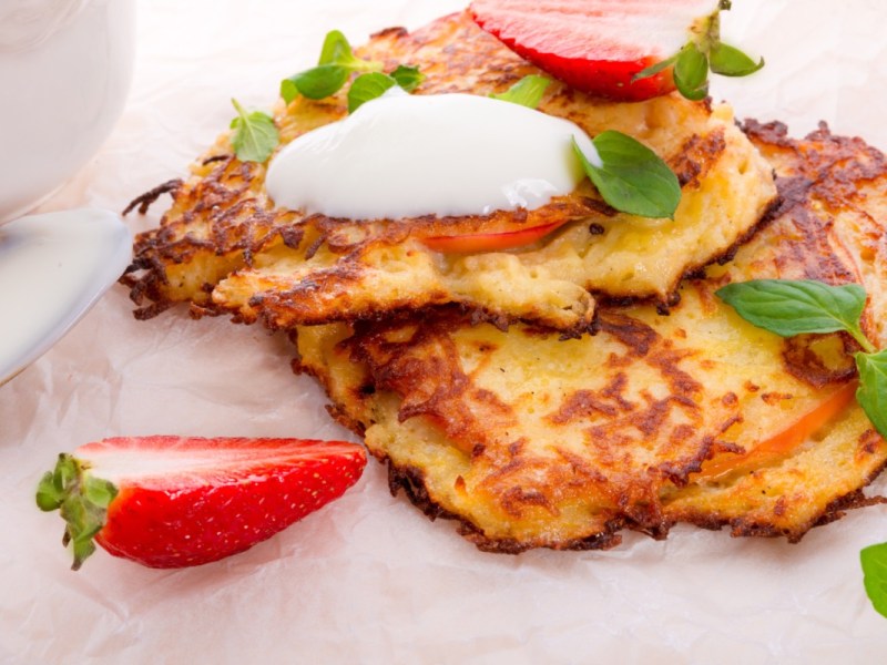 Zwei Kartoffelpuffer mit Erdbeeren und Joghurt.