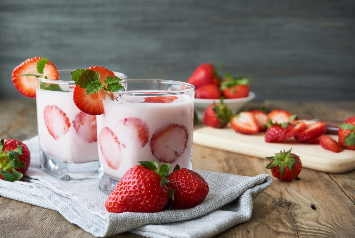 Zwei Gläser Yogurette-Dessert auf einem Tisch mit Erdbeeren