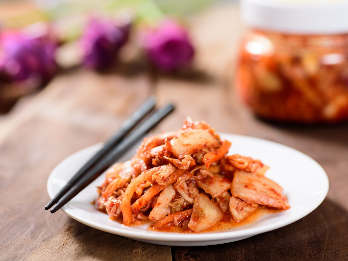 Kimchi selber machen: Eine Portion Kimchi in einer weißen Schale. Daneben liegen Essstäbchen.