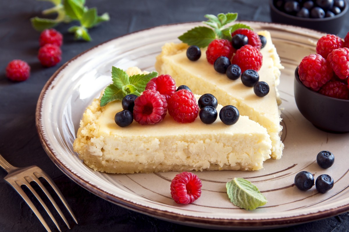 2 Stücke No-Bake-Kuchen auf einem Teller, garniert mit Beeren.