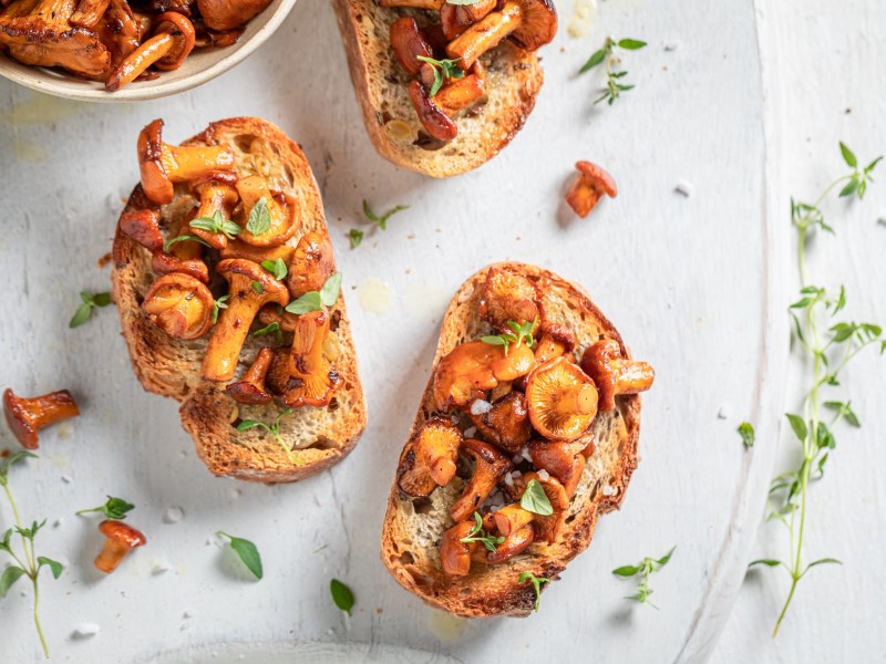 Drei Bruschetta mit Pfifferlingen auf einem Teller