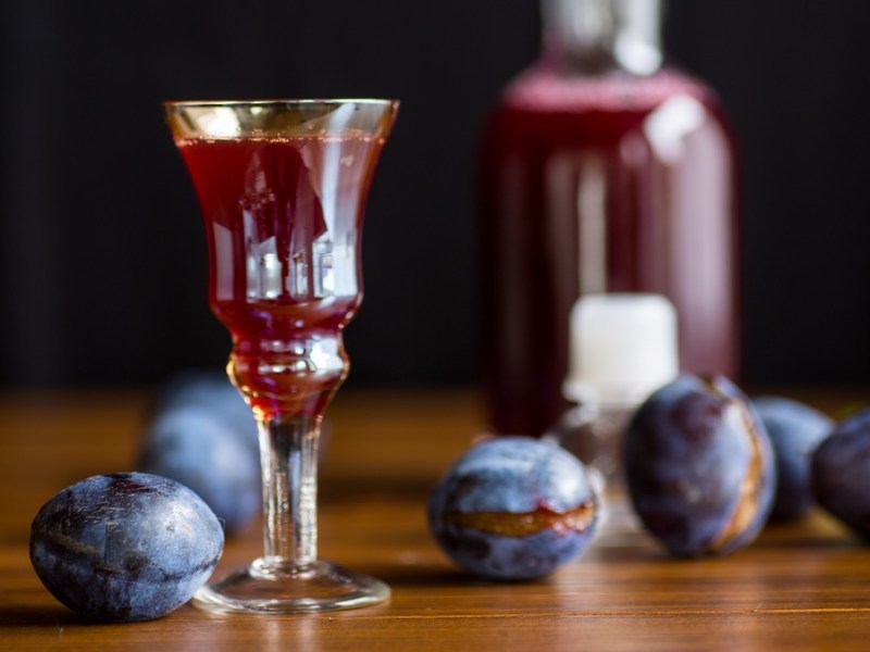 Pflaumenlikör in kleinem Glas auf dunklem Hintergrund.