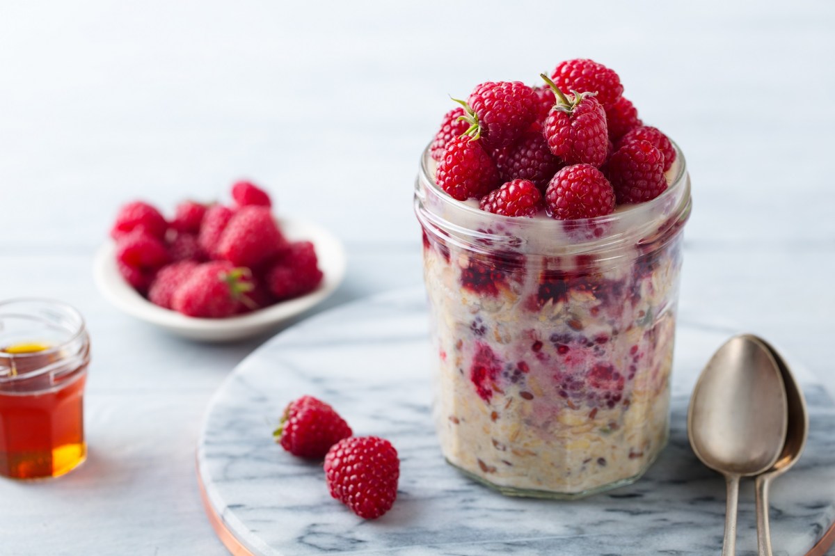 Bircher Müsli mit Himbeeren in einem Marmeladenglas.