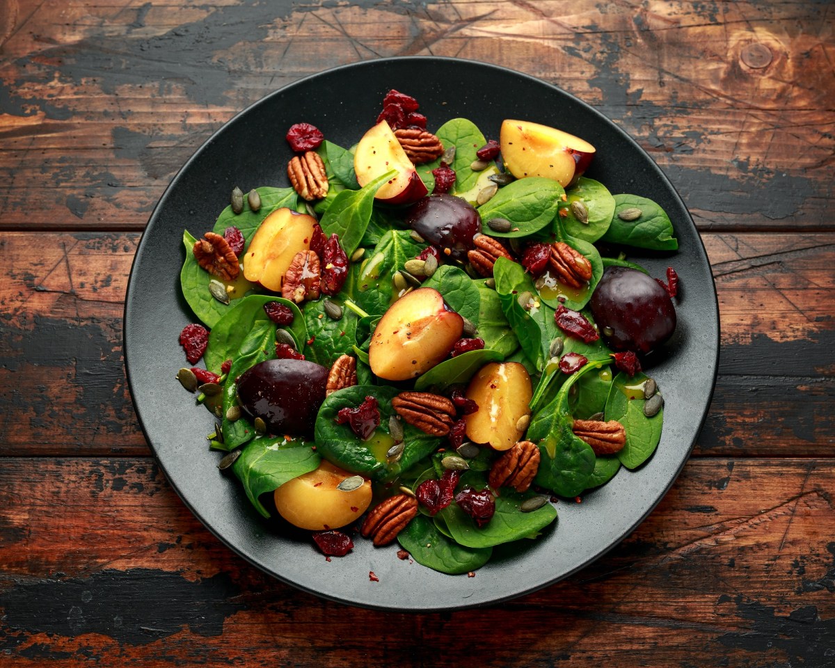 Schüssel mit Salat mit karamellisierten Pflaumen und Pekannüssen