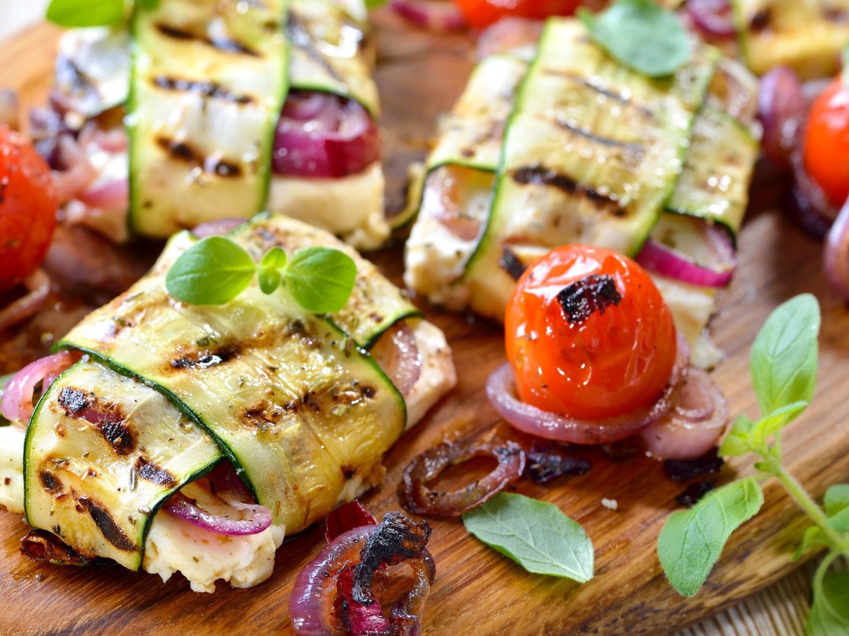 Holzbrett mit Feta-Zucchini-PÃ¤ckchen vom Grill