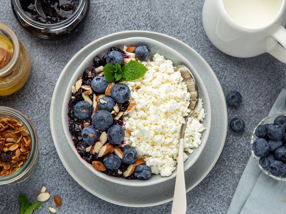 Eine Hüttenkäse-Bowl mit Pflaumenkompott und Beeren.