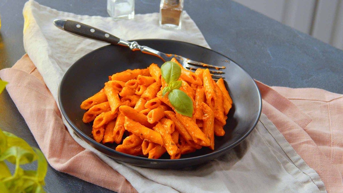 One-Pot-Penne mit Tomate-Mozzarella auf einem Teller.