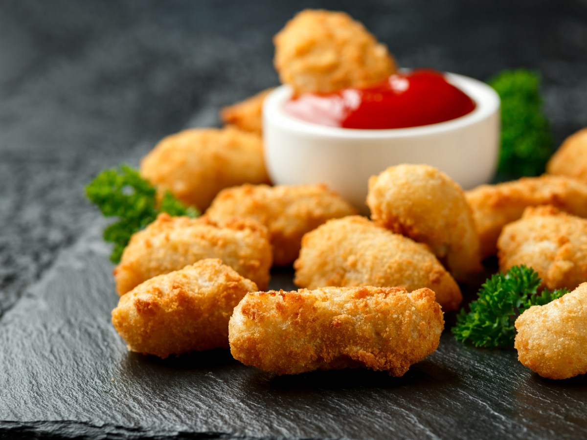 Tater Tots auf einer Marmorplatte mit einer Schüssel Ketchup.