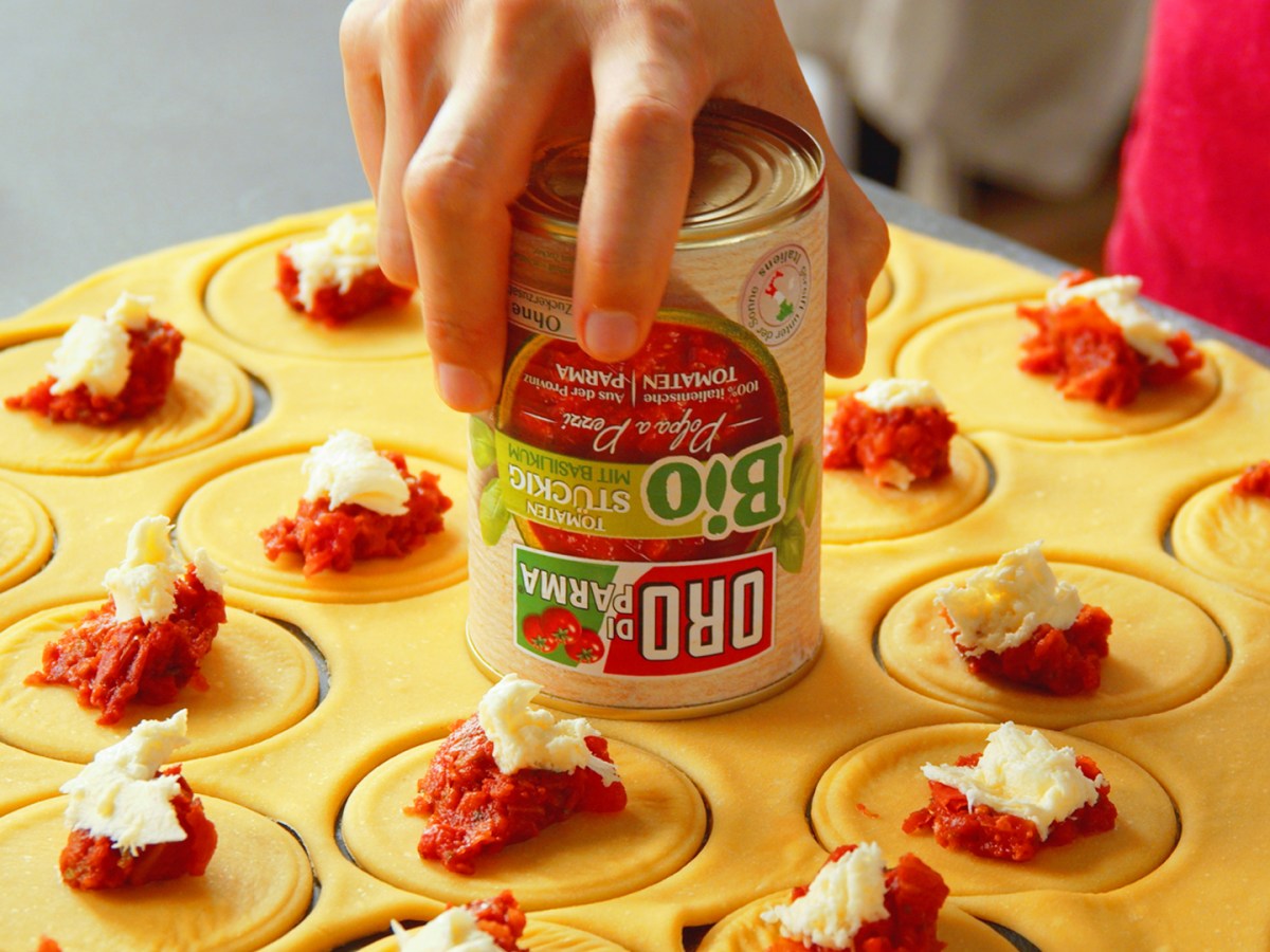 Tomaten-Käse-Ravioli mit Mozzarella und Salbeibutter: runde, mit Tomaten und Mozzarella bestückte Teiglinge.