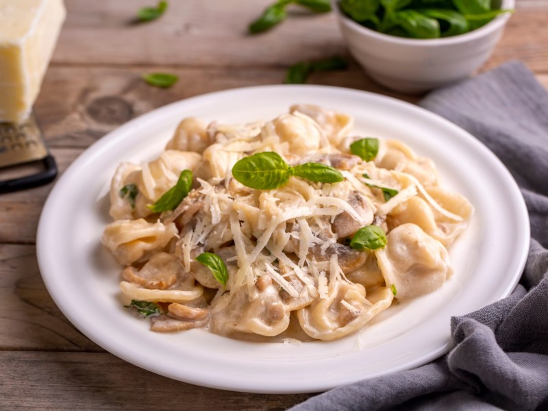 Tortellini in Pilzsoße auf einem Teller.