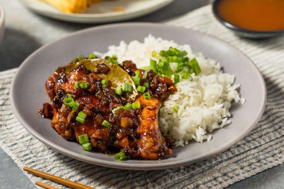 Chicken Adobo mit Reis auf einem grauen Teller.