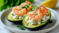 Zwei gefüllte Avocados mit Hüttenkäse und Garnelen auf einem Teller.