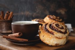 Kaffee-Zimtschnecken neben einer Kaffeetasse.