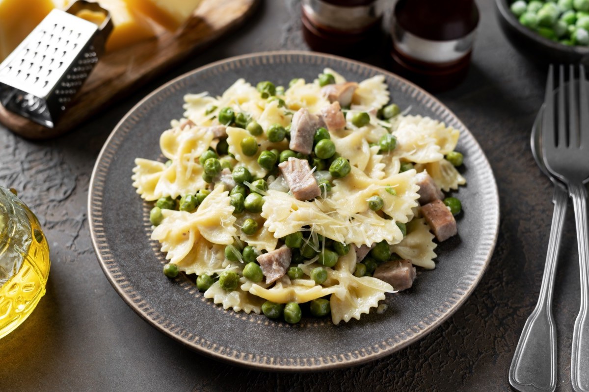 Ein Teller mit Pasta à la Chef. Daneben liegen Besteck und Zutaten.