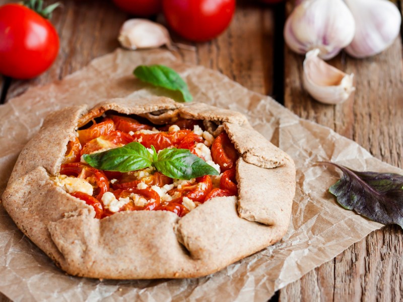 Tomaten-Feta-Galette auf einem Stück Backpapier