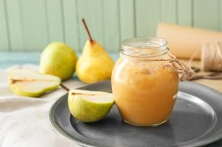 Ein Glas Birnen-Ingwer-Marmelade auf einem Silbertablett.