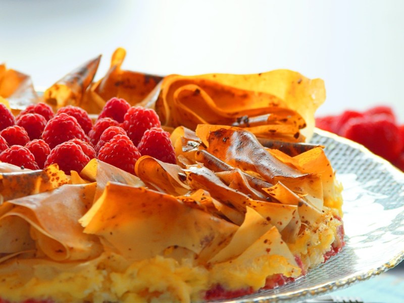 Blumenkuchen aus Filoteig mit Himbeeren auf einem Teller.