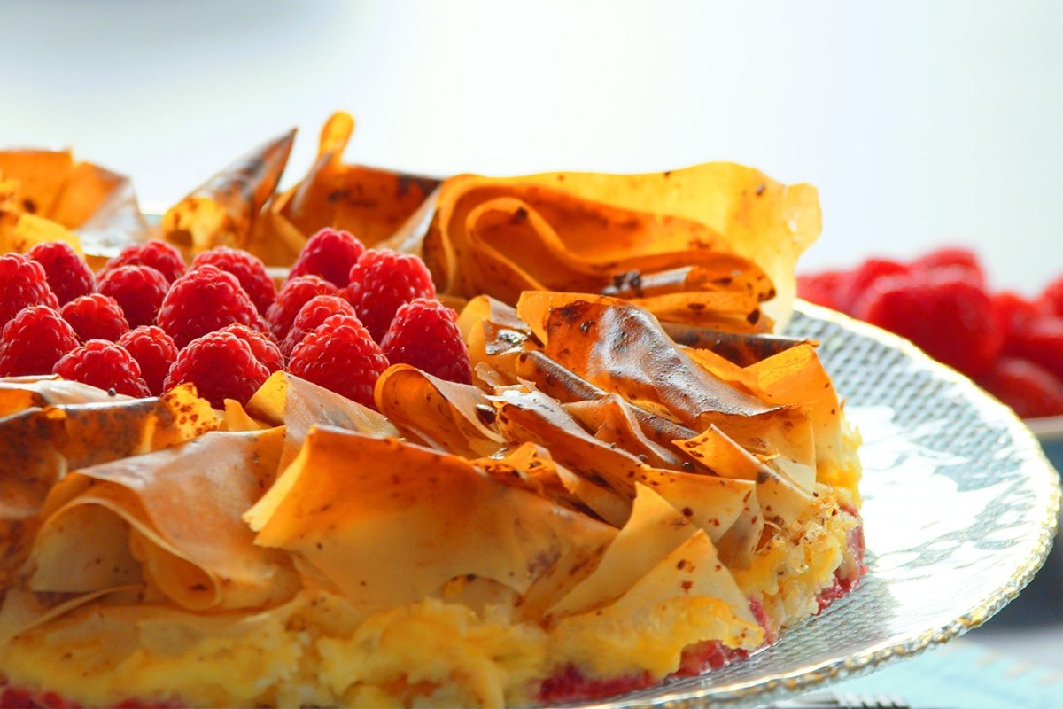 Blumenkuchen aus Filoteig mit Himbeeren auf einem Teller.