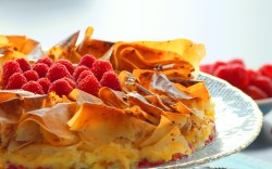 Blumenkuchen aus Filoteig mit Himbeeren auf einem Teller.