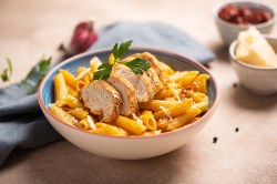 Eine Schale Cajun Chicken Pasta mit Petersilie garniert.