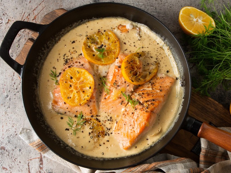 Lachs in Zitronen-Sahnesoße in einer gusseisernen Pfanne.