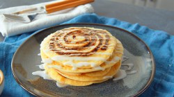 Zimtschnecken-Pancakes mit Glasur auf einem Teller.