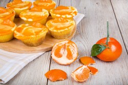 Käsekuchen-Muffins aus der Heißluftfritteuse, davor eine frische Mandarine.