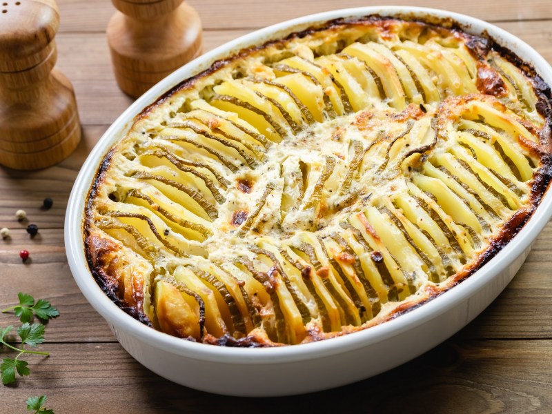 Kartoffel-Zucchini-Gratin in ovaler Auflaufform.