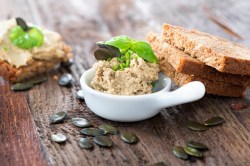 Schale mit Kürbiskern-Aufstrich mit Brot und Kürbiskernen