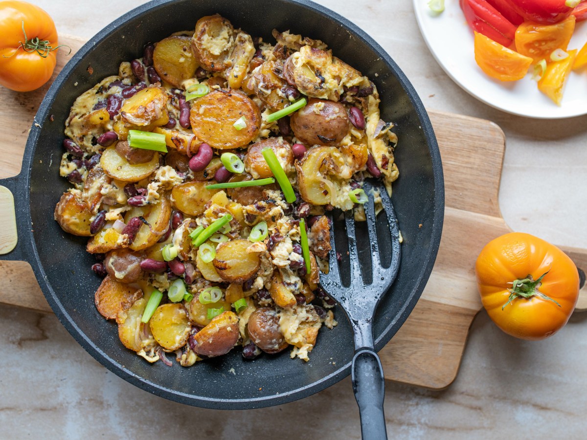 Eine Pfanne mit Bratkartoffeln mit Ei und Bohnen.