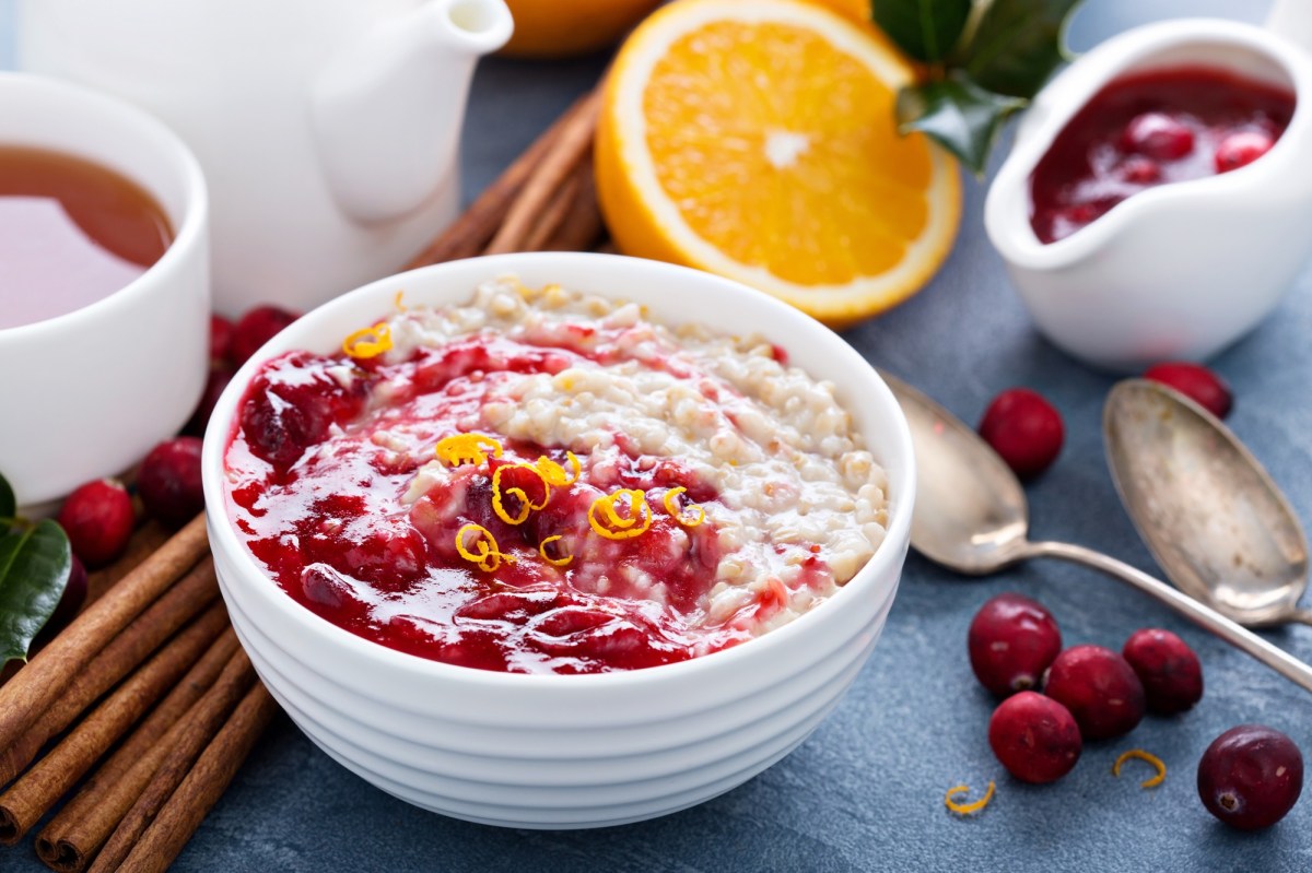 Eine SchÃ¼ssel Cranberry-Porridge mit etwas Orange.