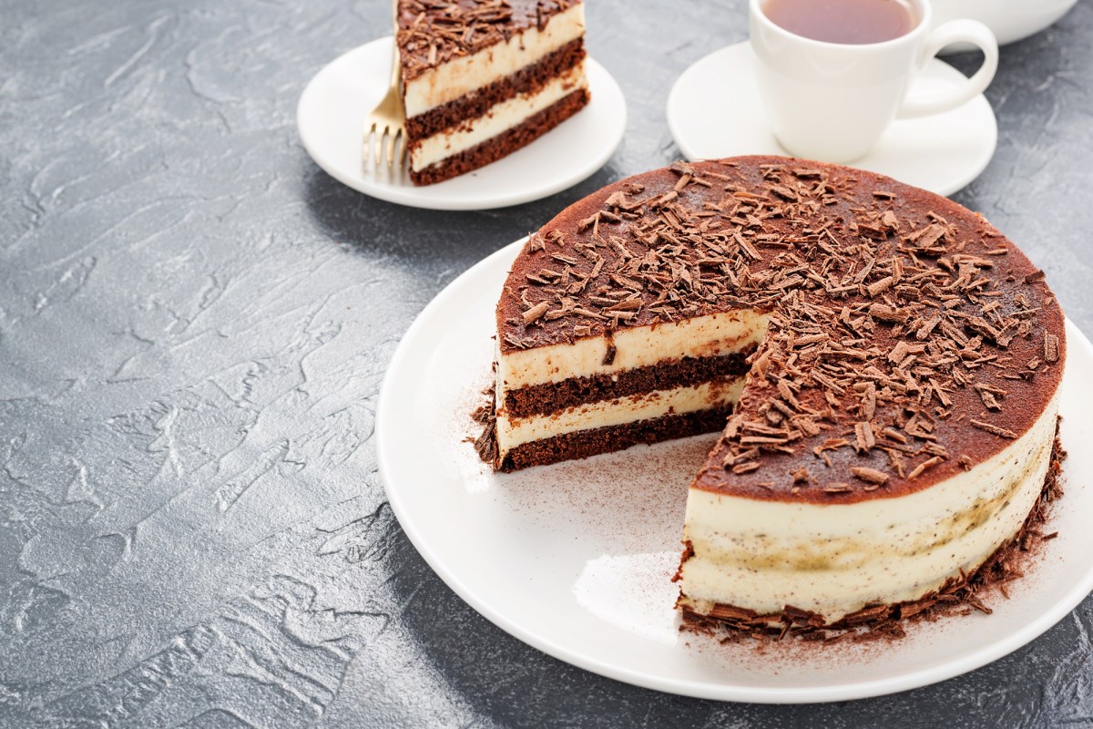 Eine EierlikÃ¶r-Tiramisu-Torte, von der ein StÃ¼ck abgenommen wurde. Daneben steht eine Tasse Kaffee.