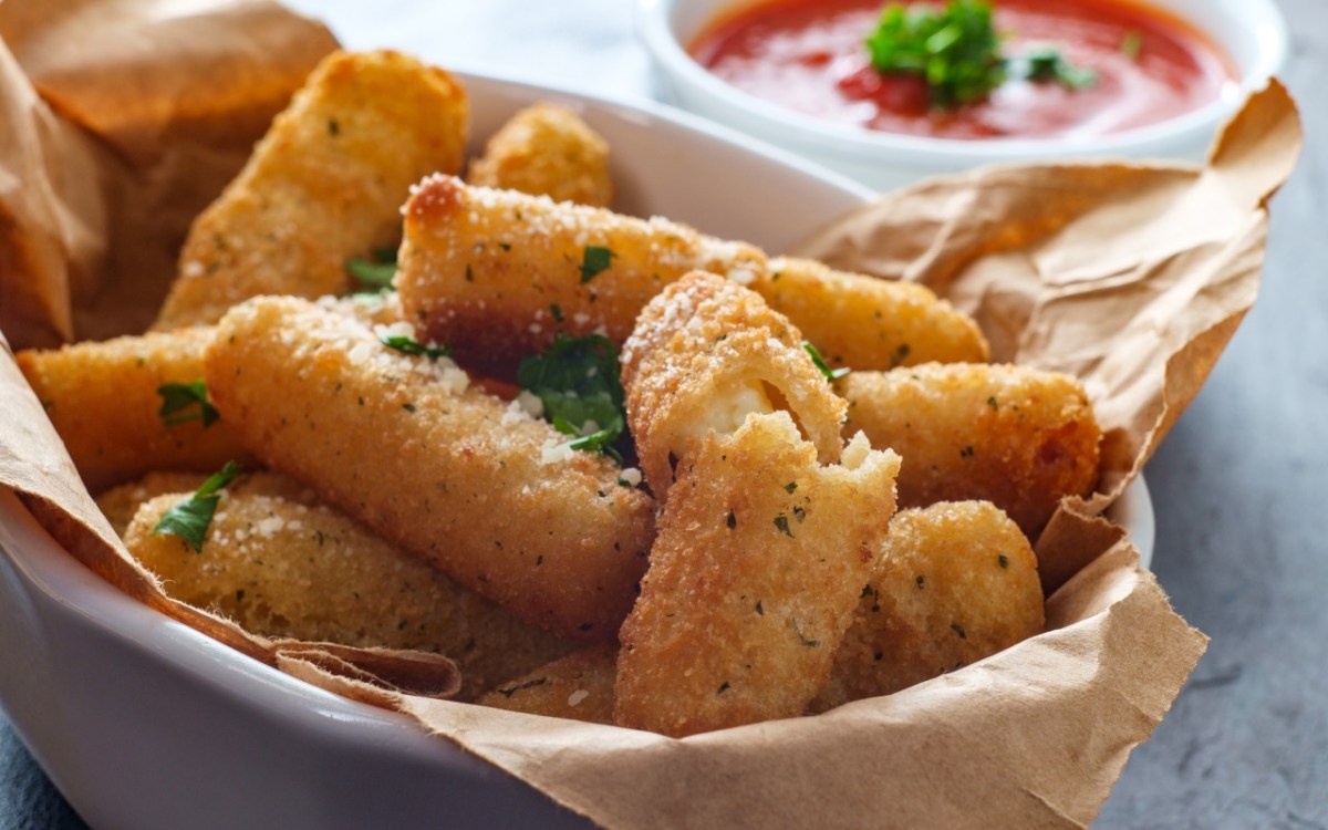 Mozzarella-Sticks aus der HeiÃŸluftfritteuse in einer Schale. Daneben ein SchÃ¤lchen mit Ketchup.