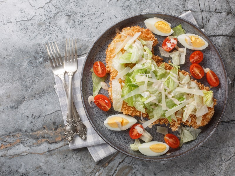 Teller mit Caesar-Salad-Schnitzel in der Draufsicht