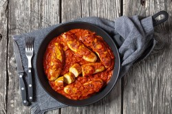 Currywurst-Pfanne mit Besteck daneben