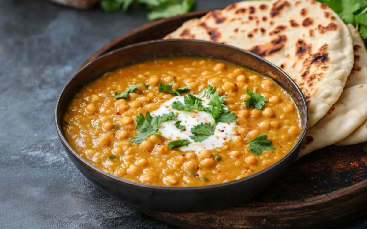 Eine SchÃ¼ssel veganes Kichererbsen-Dal mit Naan-Brot.