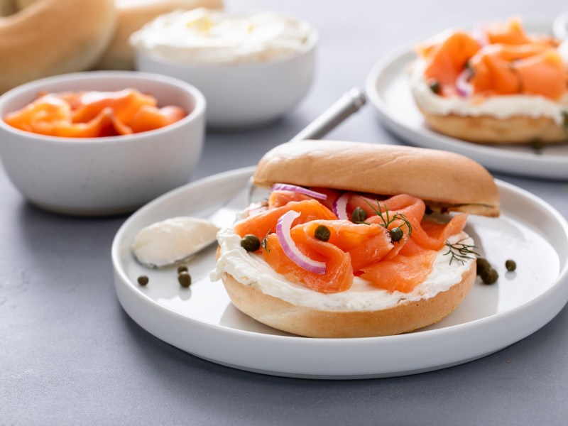 RÃ¤ucherlachs-Bagels mit Kapern und Dill auf mehreren Tellern.